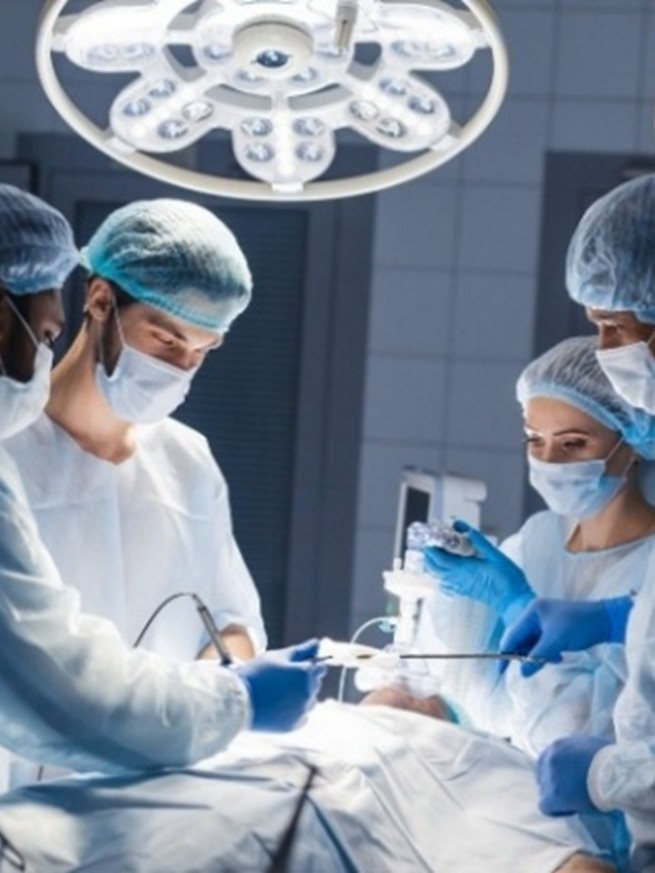 medical setting operating room team of surgeons and nurses performing laser surgery